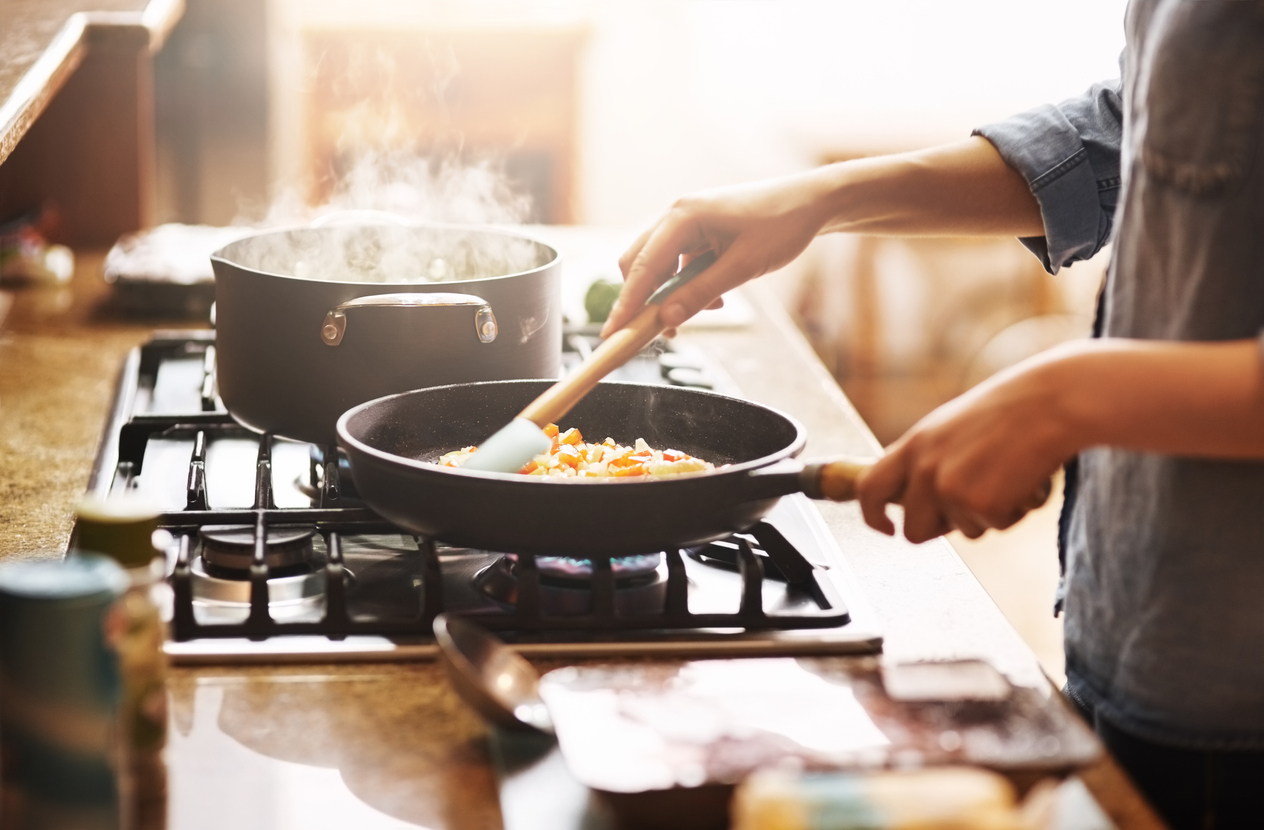 disembodied hands cooking something in a pan.